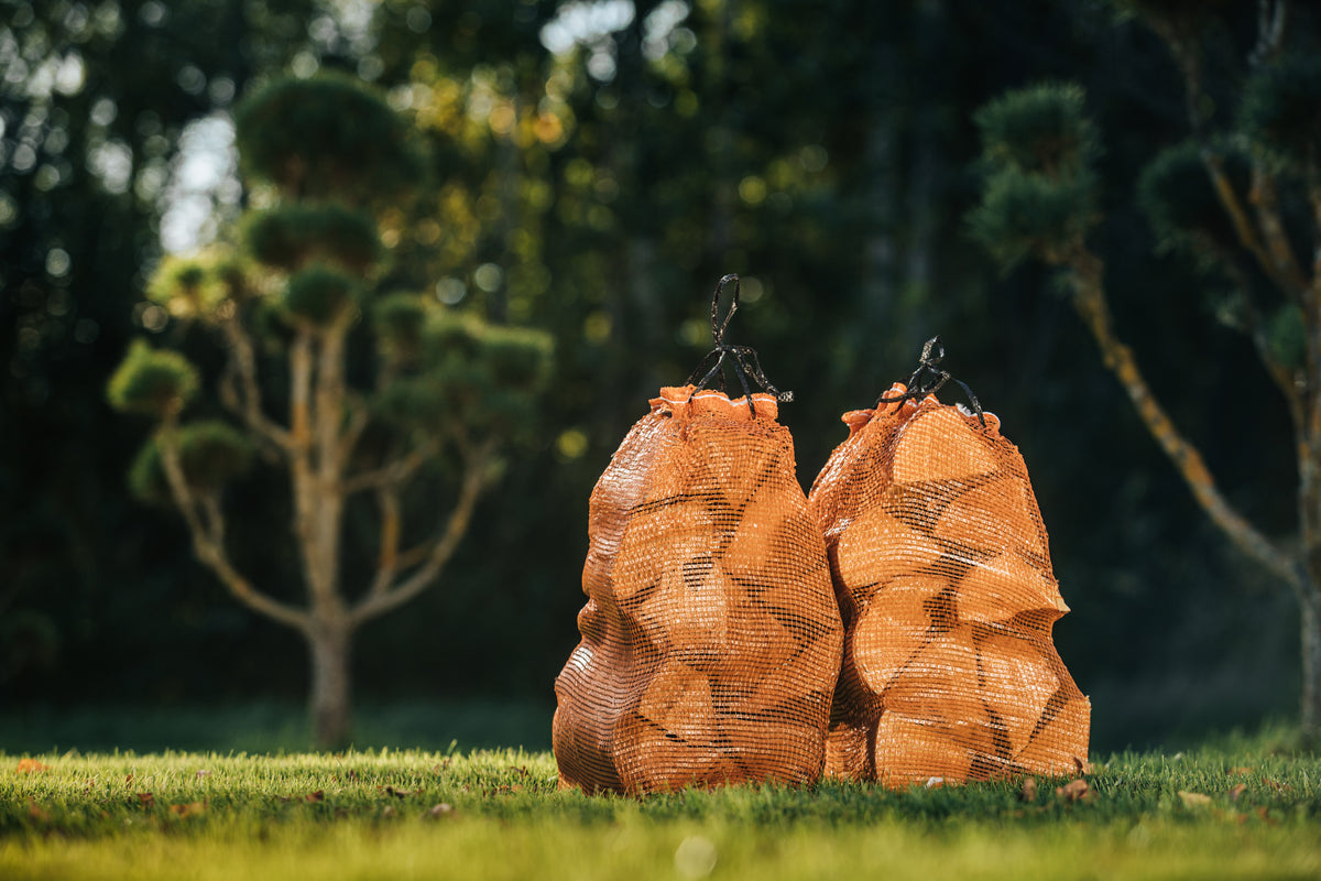Two firewood net bags on grass